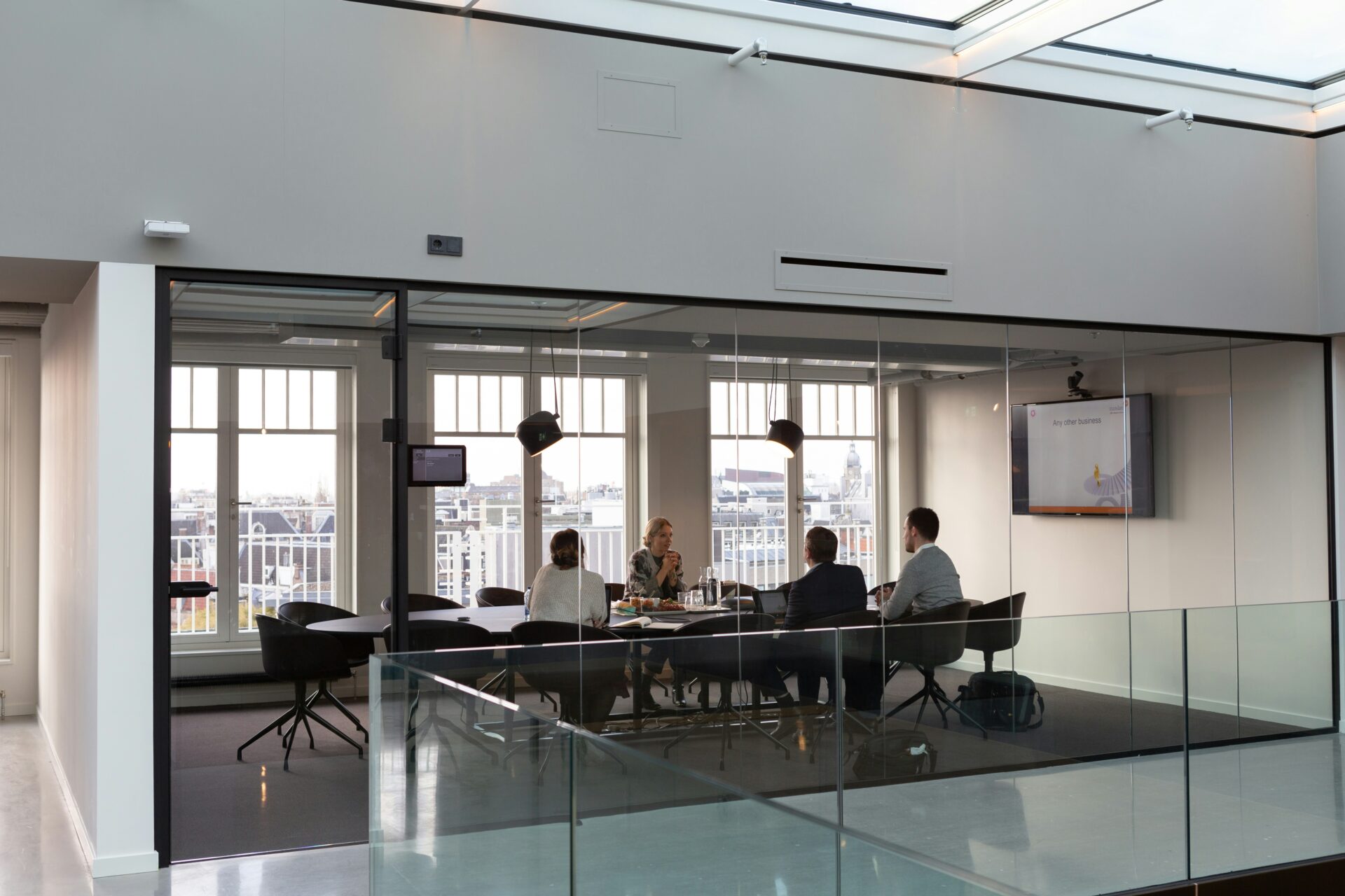 A group of people sitting at a table in front of a window.